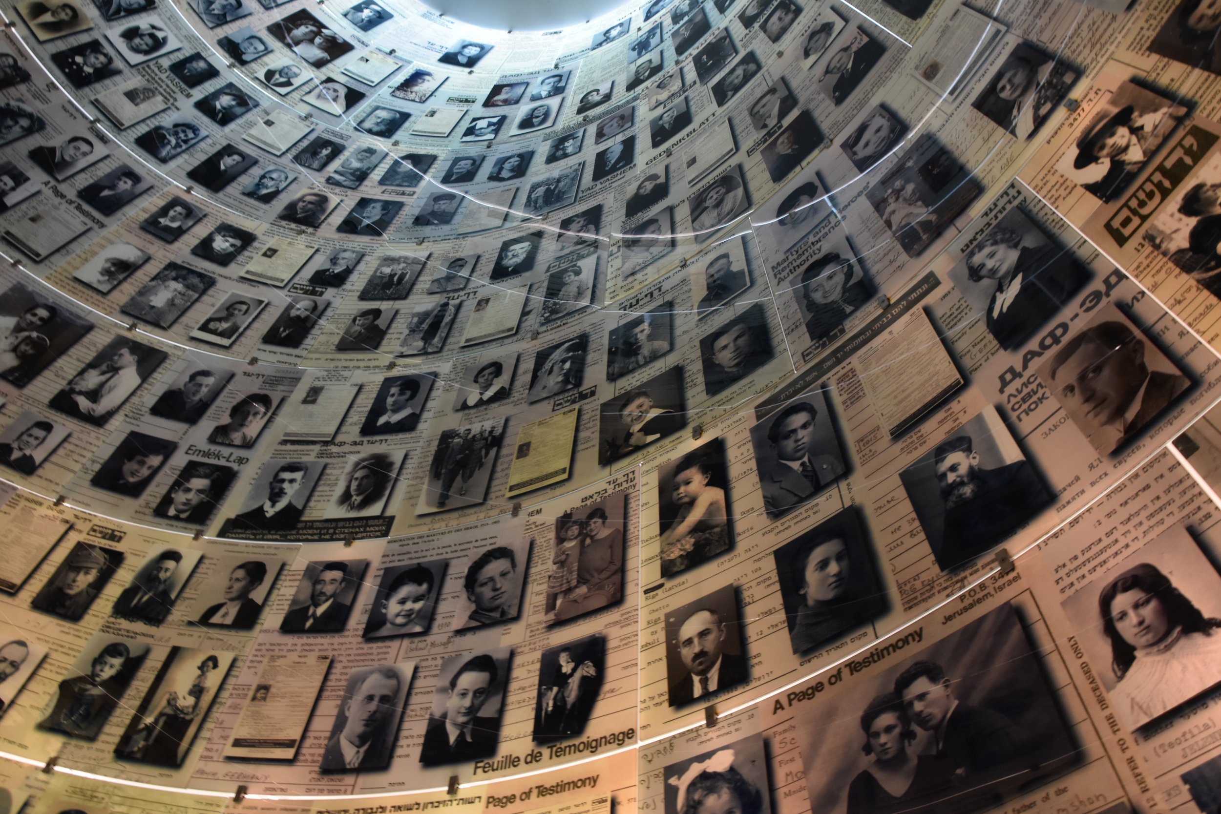 Holocaust memorial wall with photographs and testimony pages